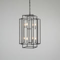 Modern black chandelier hanging in a room with beige walls and a window.
